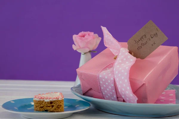 Geschenkkarton, Blumenvase und Keks auf Holzoberfläche — Stockfoto