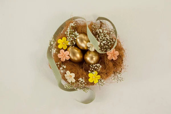 둥지에 꽃과 함께 황금 부활절 달걀 — 스톡 사진