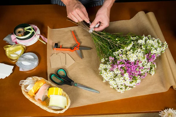 Male florist preparing a flower bouquet — Stock Photo, Image