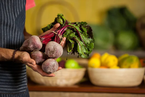 Mid section of male staff holding turnip in organic section — Stock Photo, Image