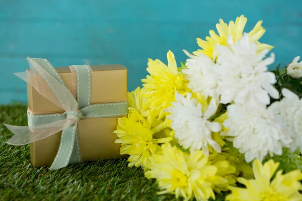 Scatola regalo con fiori sull'erba — Foto Stock