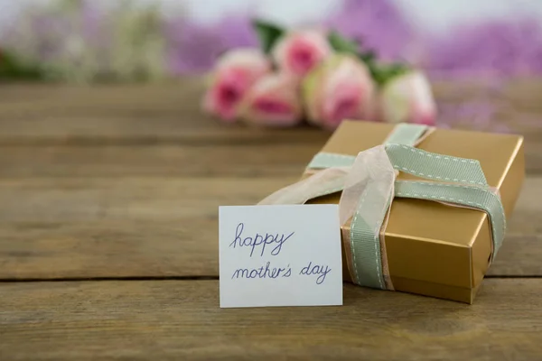 Gift box with happy mother day card on wooden surface — Stock Photo, Image