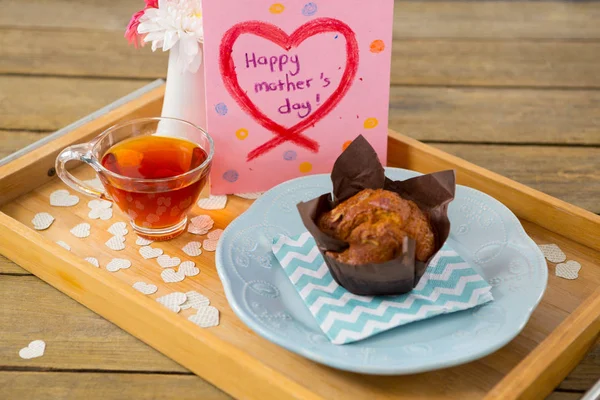 Cupcake, chá, vaso de flores e feliz mãe cartão de cumprimentos do dia na bandeja — Fotografia de Stock