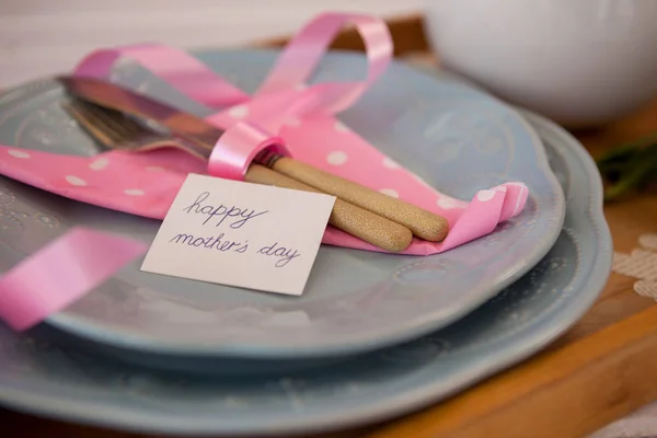 Cutlery, napkin with happy mothers day card on plate — Stock Photo, Image