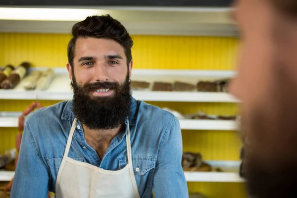 Uśmiechnięty personel mężczyzna stojący o sklep mięsny — Zdjęcie stockowe