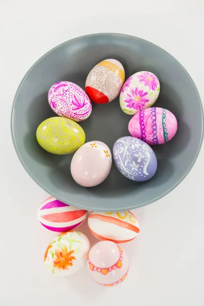 Cuenco con huevos de Pascua pintados sobre fondo blanco — Foto de Stock