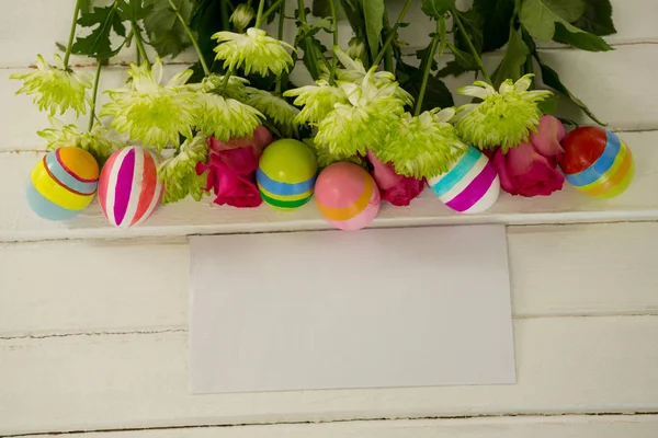 Ovos de Páscoa, cacho de flores e envelope — Fotografia de Stock