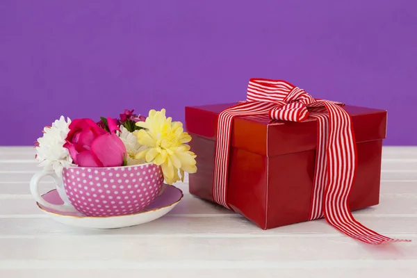 Confezione regalo e fiori freschi su superficie in legno — Foto Stock