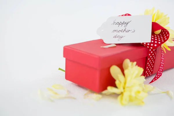 Pudełko z matek szczęśliwy dzień tag i żółty kwiat — Zdjęcie stockowe
