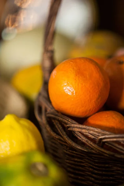 Close-up of fresh oranges in wicker basket at organic section — Stock Photo, Image