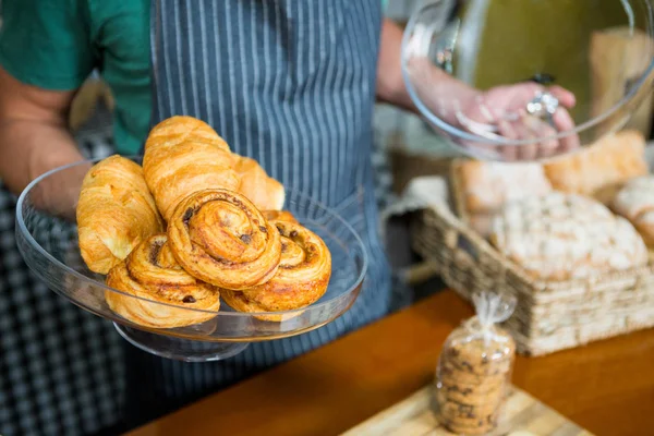 Anställda som innehar fack croissant på counter — Stockfoto