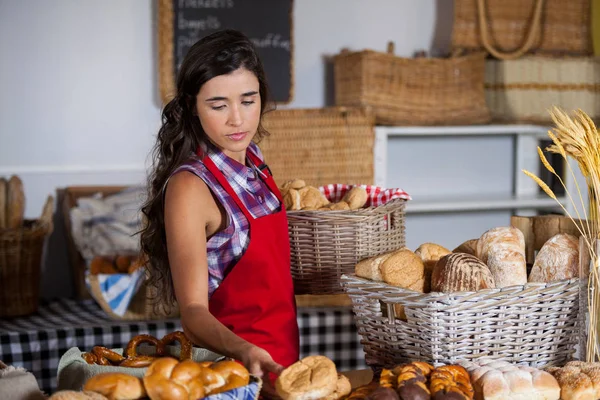 Personal femenino sosteniendo canasta de alimentos dulces en la sección de panadería — Foto de Stock