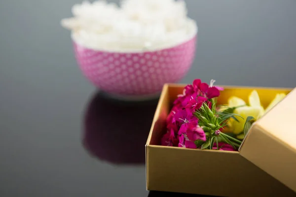 Opened gift box and bowl with flowers — Stock Photo, Image