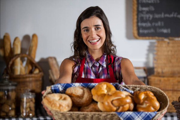 Portrait of female staff holding basket of sweet foods — Stock Photo, Image