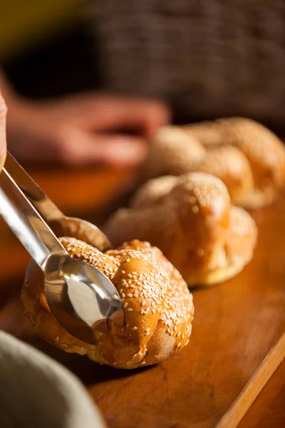 Hand des weiblichen Personals hält süßes Essen mit einer Zange in der Hand — Stockfoto