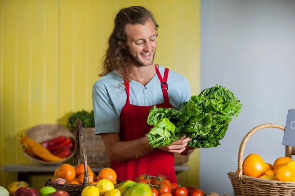 Usmívající se personál při pohledu na listová zelenina na přepážce — Stock fotografie