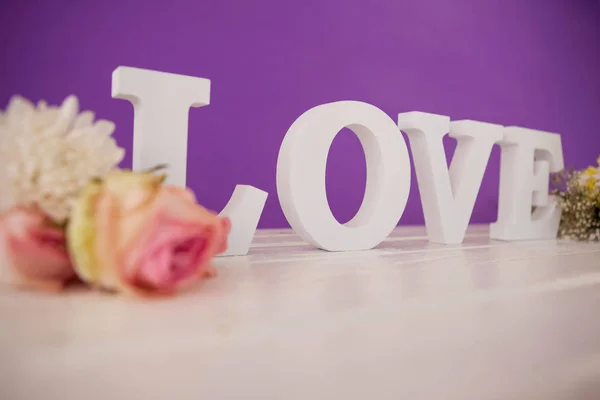 Flores con alfabetos formando amor en la mesa — Foto de Stock