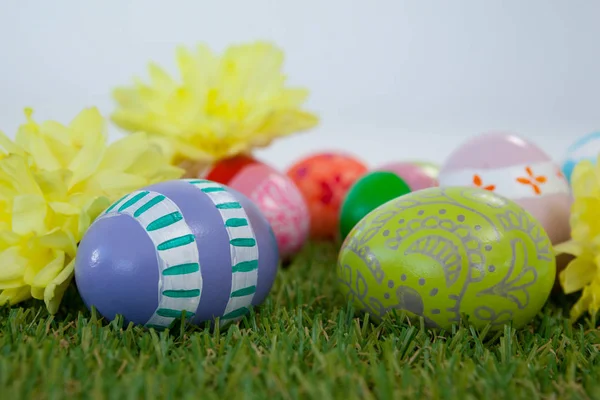 Uova di Pasqua dipinte con fiori sull'erba — Foto Stock