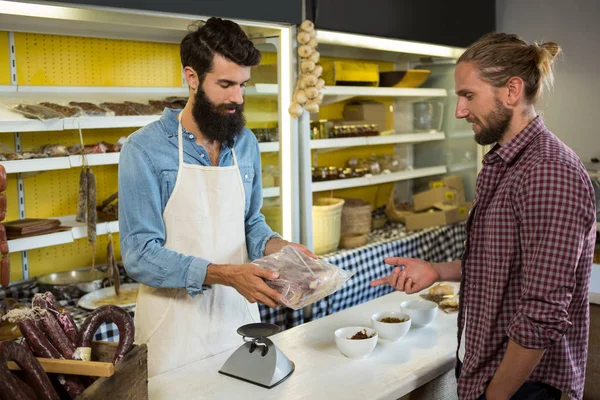 Cliente recibiendo carne envasada en el mostrador — Foto de Stock