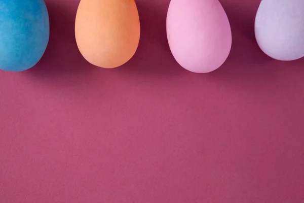 Oeufs de Pâques disposés sur fond rose — Photo