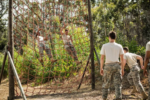 Військові солдати під час перешкод піднімаються на мотузку — стокове фото
