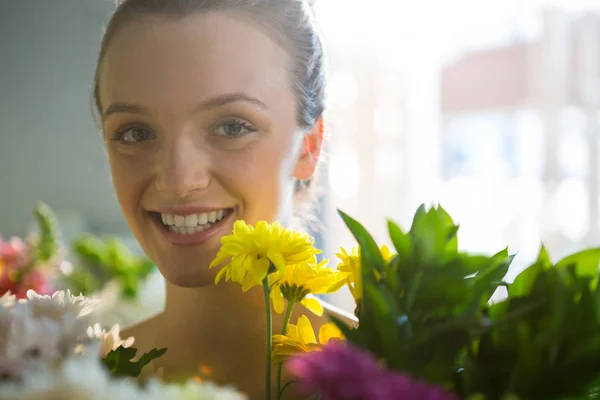 Lachende vrouw die permanent in de bloemenwinkel — Stockfoto