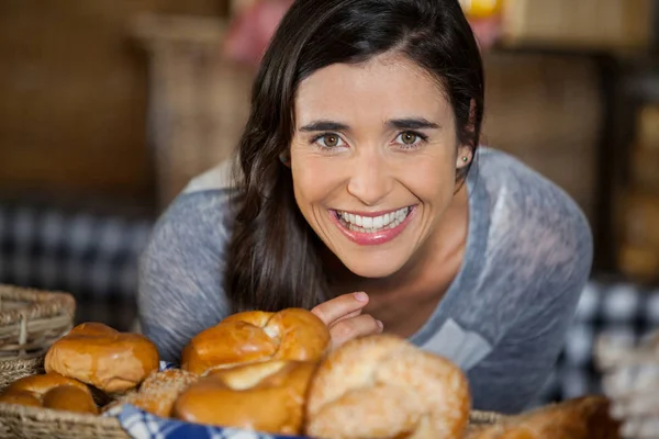 Mujer sonriente mirando panes en el mostrador — Foto de Stock