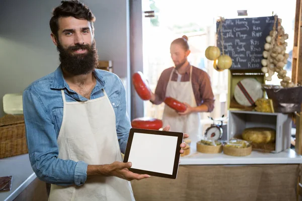 Portrait of smiling staff showing digital tablet at counter — Stock Photo, Image