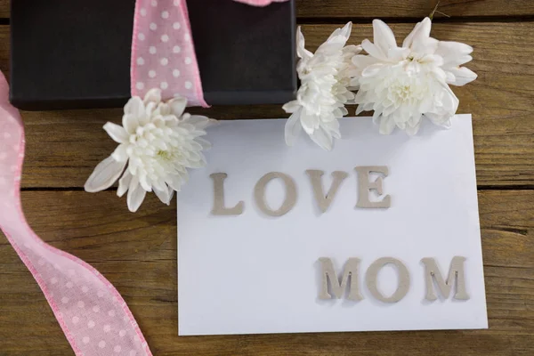 Geschenkdoos met liefde moeder tekst op houten plank — Stockfoto