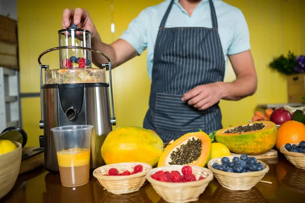 Shop assistant preparing fruit juice — Stock Photo, Image