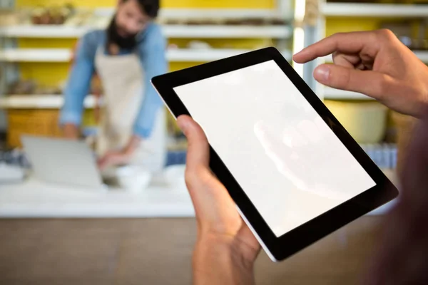 Personeel met behulp van digitale tablet bij bakkerij balie — Stockfoto