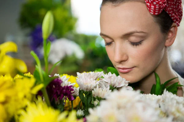 Floristin riecht einen Blumenstrauß — Stockfoto