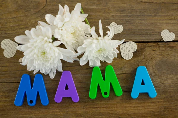 Heart shape with alphabet reading mama and white flowers — Stock Photo, Image