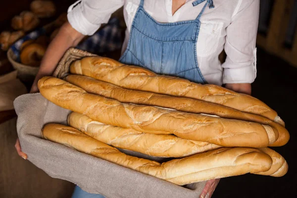 Női alkalmazottak gazdaság kosár bagettet pékség szakasz középső szakasza — Stock Fotó