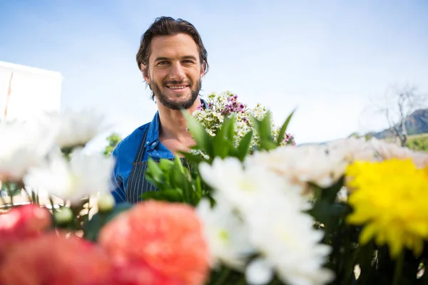 Fleuriste souriant tenant un bouquet de fleurs dans un magasin de fleuristes — Photo