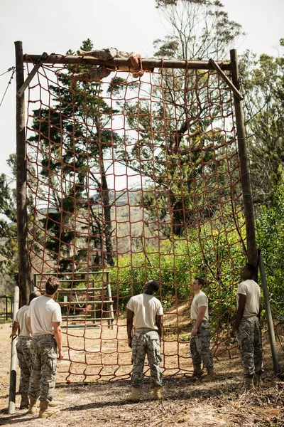 Soldat militaire grimpant à la corde pendant le parcours d'obstacles — Photo