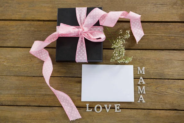 Geschenkdoos met mama liefde tekst op houten plank — Stockfoto