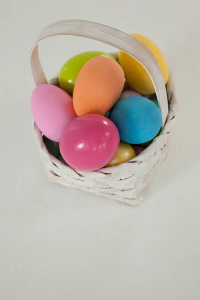 Various Easter eggs in wicker basket — Stock Photo, Image