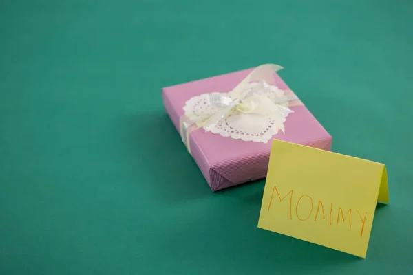 Geschenkbox mit Text Mama auf Karte vor grünem Hintergrund — Stockfoto