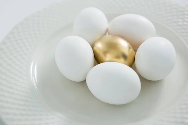 Plaka beyaz yumurta ile altın Paskalya yortusu yumurta — Stok fotoğraf