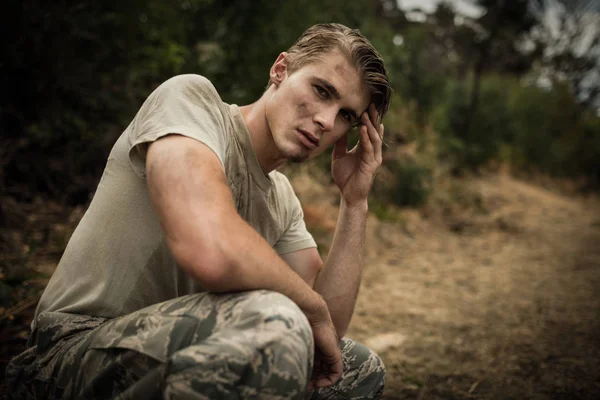 Soldado cansado com a mão na cabeça sentado no acampamento de inicialização — Fotografia de Stock