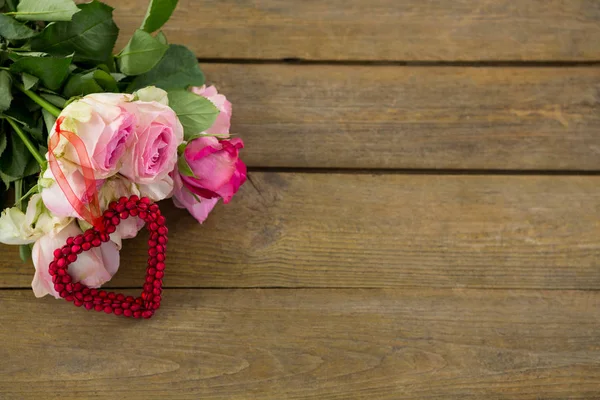 Ramo de rosas rosadas sobre tabla de madera —  Fotos de Stock