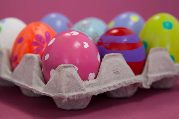 Œufs de Pâques colorés dans un carton d'œufs — Photo