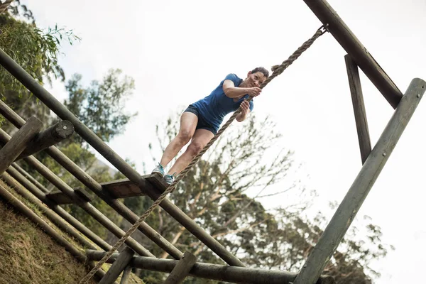 Mujer en forma sosteniendo la cuerda durante la carrera de obstáculos —  Fotos de Stock