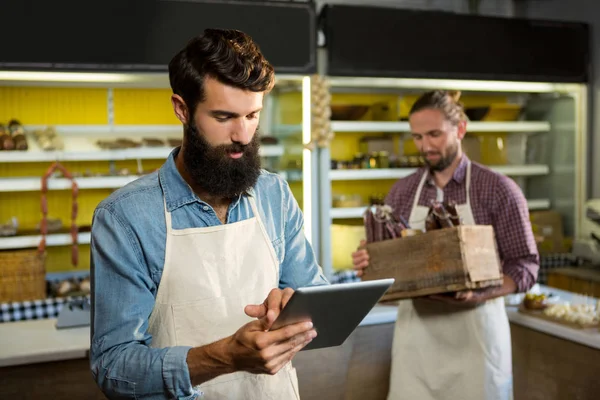 Personal atento usando tableta digital en el mostrador de panadería — Foto de Stock