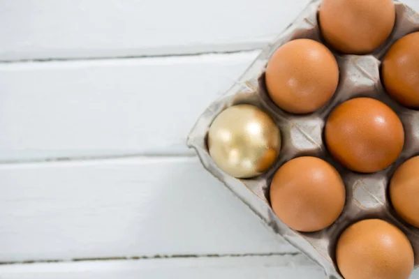 Kahverengi yumurta içinde tepsi ile altın Paskalya yortusu yumurta — Stok fotoğraf