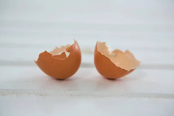 Broken brown Easter egg on wooden surface — Stock Photo, Image