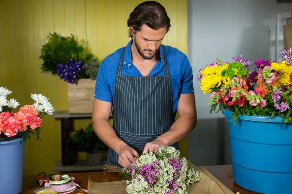 Manliga florist förbereder en blombukett — Stockfoto