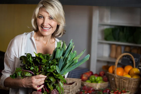Retrato del cliente femenino sosteniendo verduras frescas en sección orgánica — Foto de Stock