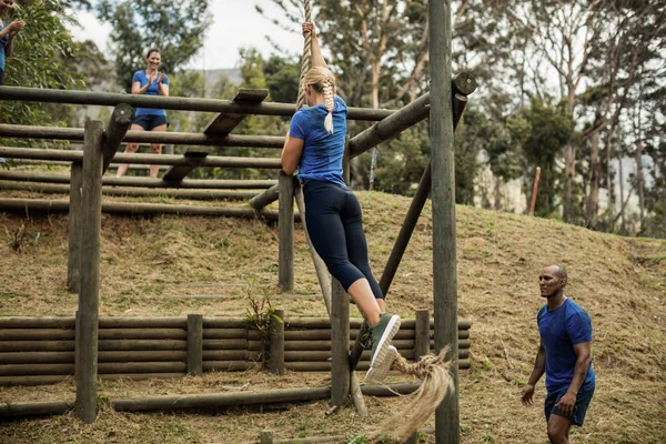 Femme en forme descendant la corde pendant le parcours d'obstacles — Photo